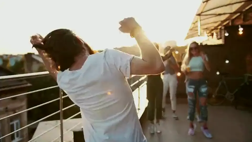 Friends dancing under string lights on a terrace